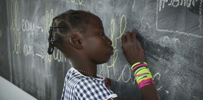 A girl writes on a blackboard