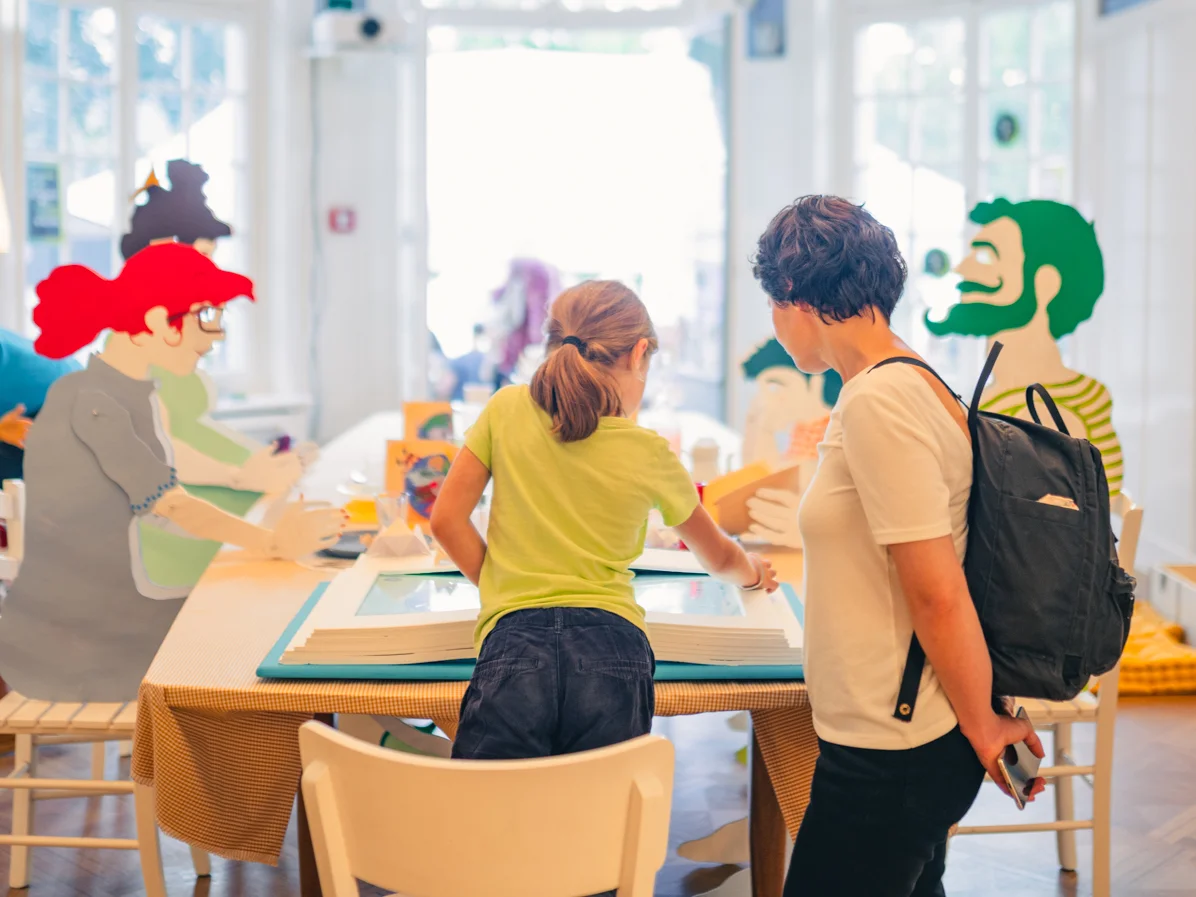 Mother and daughter interacting with one of the screens in an exhibition