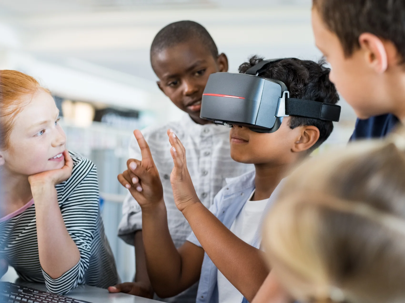 A primary school child uses a virtual reality headset with other children around them