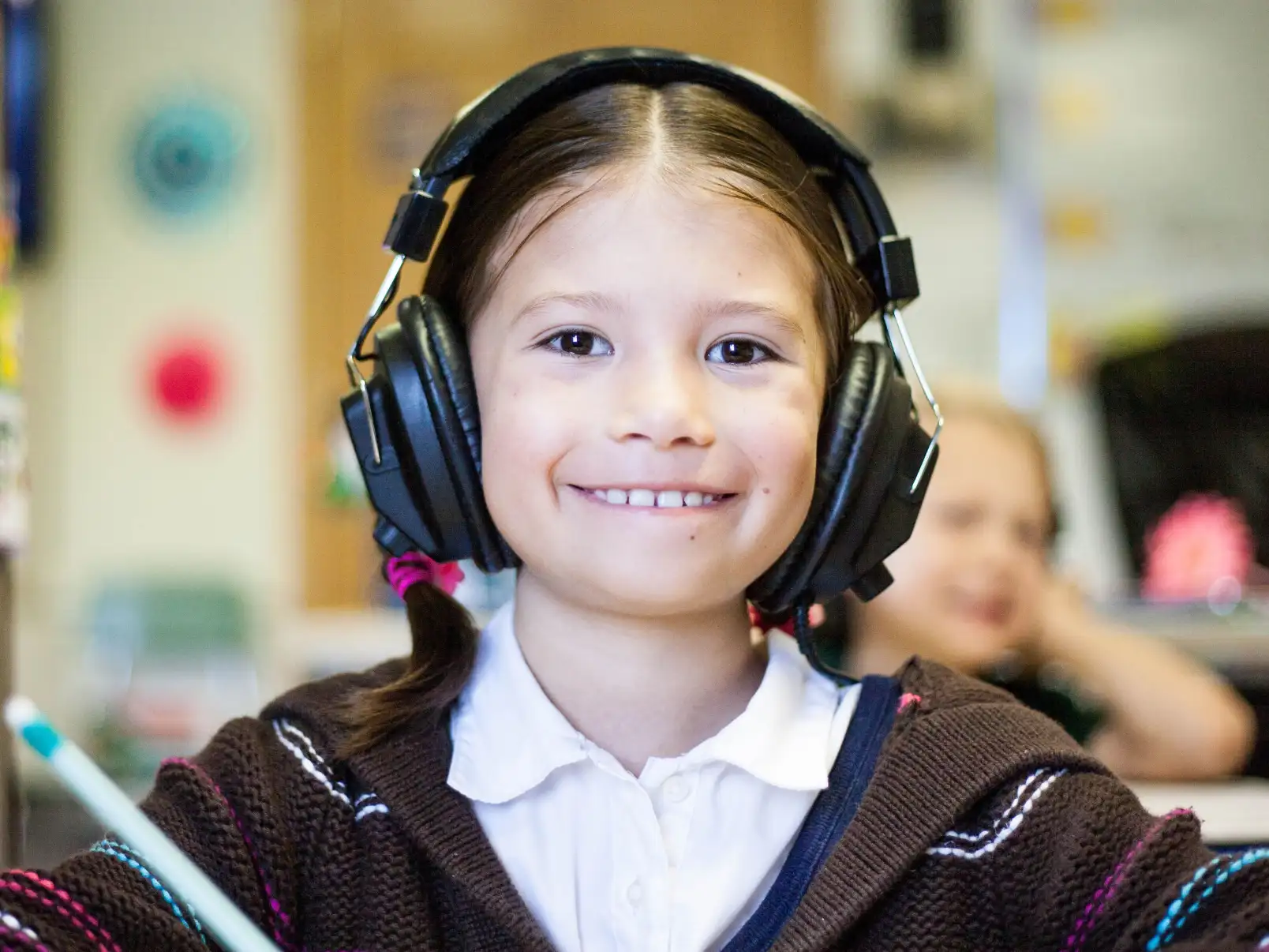 A girl wearing headphones in a classroom